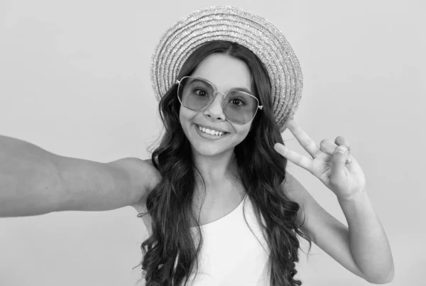 Feliz chica adolescente en verano sombrero de paja y gafas haciendo selfie sobre fondo amarillo, selfie —  Fotos de Stock