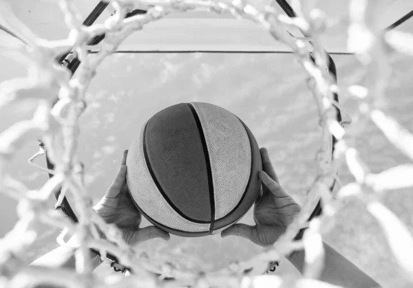 A labda átmegy a kosáron. Egy férfi dobja a labdát a gyűrűbe. kezek és kosárlabda. zsákolás kosárban. — Stock Fotó
