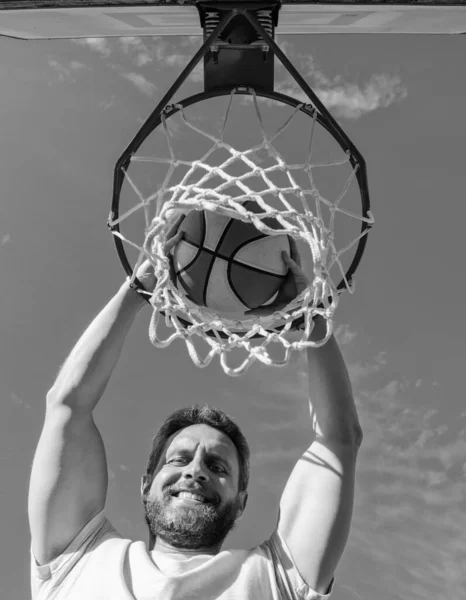 Homem feliz jogador jogar bola de basquete através da cesta, ganhando — Fotografia de Stock