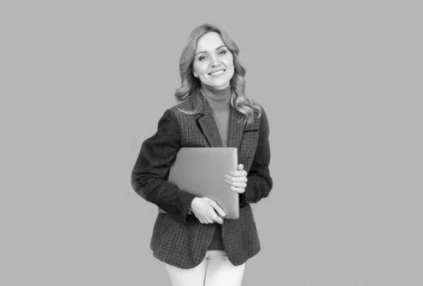 Щаслива жінка в стилі повсякденної моди тримає портативний ноутбук комп'ютер сірий фон, сучасне життя — стокове фото