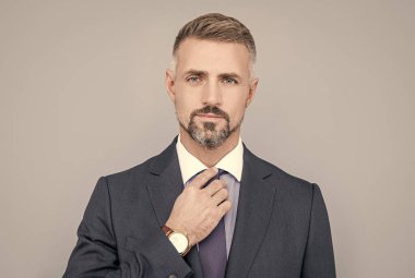 Mükemmel görünüyor. Takım elbiseli, kır saçlı bir adam. Girişimci ya da yönetici.
