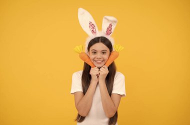 Heyecanlı hissediyorum. Tavşan kulaklı ve papyonlu çocuk. Eğlence zamanı. Çocuk havuçla komik görünüyor..