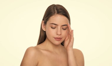 Genç bayan kusursuz yüze dokunuyor beyaz arka planda soyutlanmış ten, güzellik