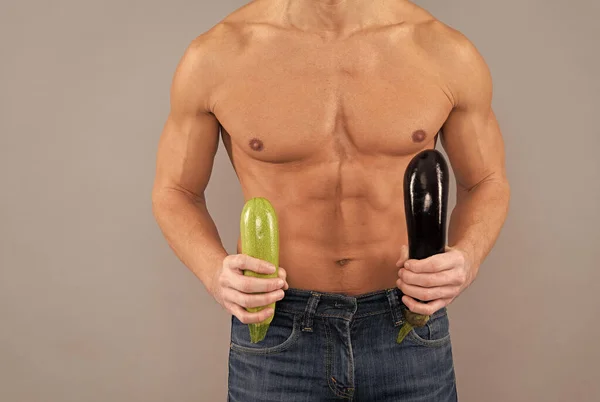 Hombre muscular con seis abdominales paquete vista recortada mantenga berenjena natural y verduras de calabacín, dieta —  Fotos de Stock
