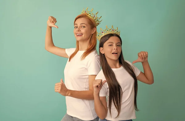 Mujer feliz y niña niño en coronas señalar los dedos en camisetas promocionales para el espacio de copia, anuncio — Foto de Stock