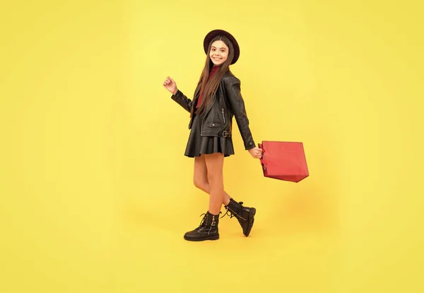Szczęśliwy nastolatek dziewczyna w kapeluszu i skórzane ubrania trzymać torba na zakupy, zakupy sprzedaż — Zdjęcie stockowe