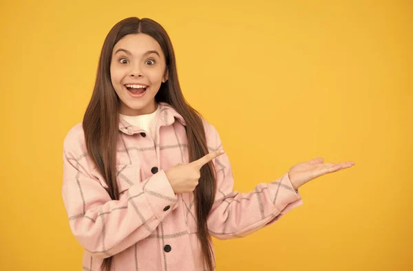 Förvånad barn flicka bära rosa rutig skjorta presentera produkt, kopiera utrymme, reklam — Stockfoto