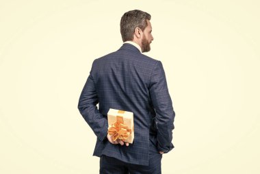 gizli arzular. İş adamı hediye kutusu saklıyor, arkadan bakıyor. Şirket hediyesi. Kadınlar Günü.