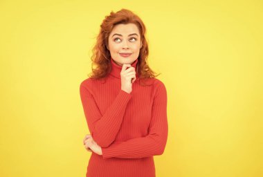 Güzel, kızıl saçlı, kıvırcık saçlı, gülümseyen ve kameraya gülen bir kızın portresi.