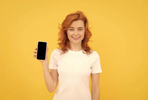 Mujer sonriente charlando en el teléfono inteligente o hacer compras en línea sobre fondo amarillo, comunicación. —  Fotos de Stock