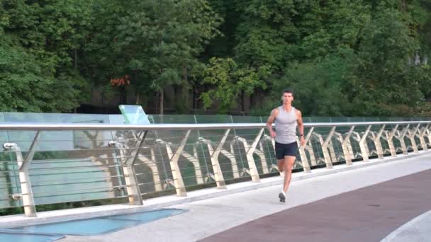 Atlético deportista muscular en ropa deportiva corriendo en la mañana al aire libre, competencia — Vídeo de stock
