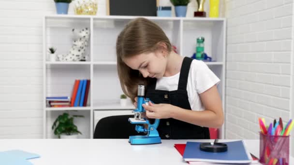 Scientifique adolescent fille regarder à travers microscope sur la chimie leçon, curiosité — Video