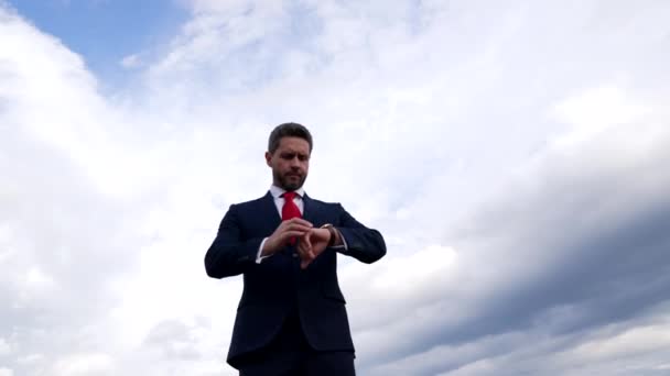 Puntual hombre profesional comprobar reloj en el cielo nublado, esperando — Vídeos de Stock
