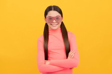 Sarı arka planda gözlüklü mutlu çocuk, moda.