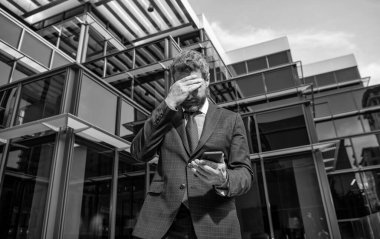 Sinirli iş adamı akıllı telefonu tutar. Kafası karışık patron konuşuyor..