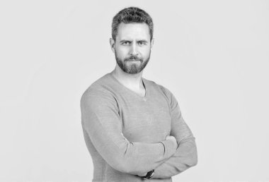 Gri arka planda sakallı, yakışıklı, olgun bir adam.