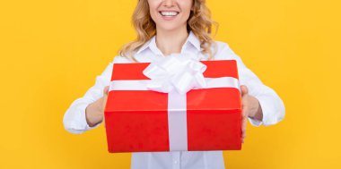 Sarı arka planda büyük hediye kutusu olan mutlu kadın.