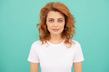 kızıl saçlı kadın gülümsüyor mavi arka planda kıvırcık saçlı