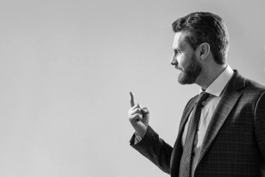 Takım elbiseli profesyonel adam parmak işaretini gri arka plan fotokopi alanı üzerinde tut.