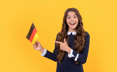 Genç kız futbol hayranı. Yönü seç. Alman bayrağını işaret eden şaşkın çocuk..