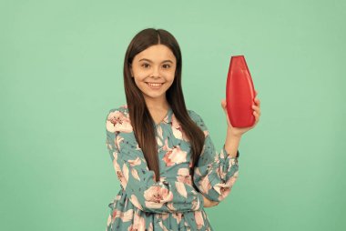 Uzun saçlı gülümseyen çocuk şampuan şişesi, kuaför.