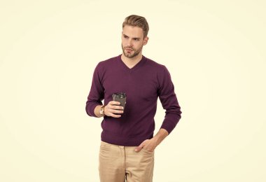 Sıradan tarzda ciddi bir adam. Tek kullanımlık kahve bardağını beyaz kafeinle izole etmiş.