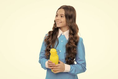 Mutlu çocuk, içinde sıvı yiyecek olan sarı plastik şişeyi beyaza, çocukluk beslenmesine izole eder.