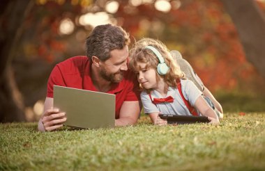 Okula dönüyorum. Baba ve oğul parkta modern iletişim teknolojisini kullanıyorlar. aile günlüğü