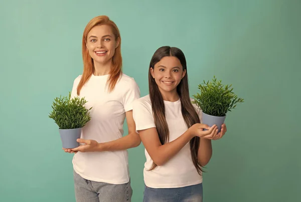 Fostering and adoption. Happy adopted child and mother hold houseplants. Foster family. Fostering