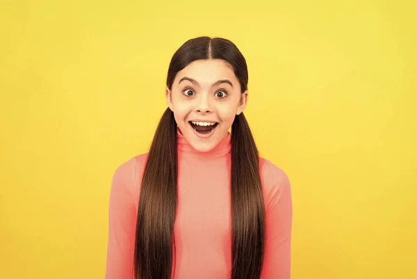 Niño sorprendido con el pelo largo sobre fondo amarillo, sorpresa —  Fotos de Stock