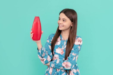 Gençler için kozmetik ürünler sunuyorum. Duş jeli çocuk. Mutlu kız şampuan şişesini tut..