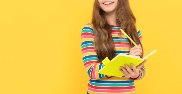 Счастливый школьник учится писать с закрытыми глазами на желтом фоне, домашняя работа — стоковое фото