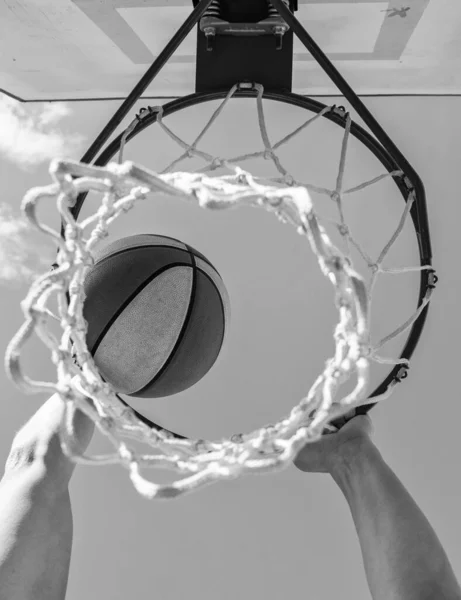 Η μπάλα περνάει μέσα από το καλάθι. Ο άνθρωπος ρίχνει την μπάλα στο στεφάνι. χέρια και μπάσκετ. — Φωτογραφία Αρχείου