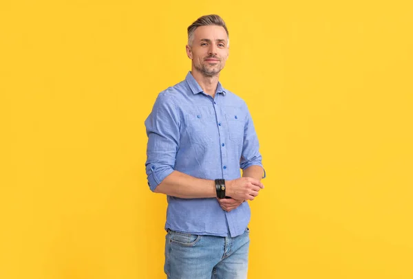 Smiling adult man with graying hair on yellow background, fashion — Stockfoto