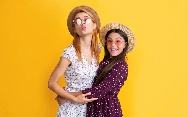 Smiling mom and daughter in straw hat on yellow background — Foto Stock