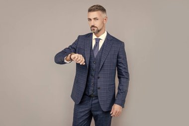 Takım elbiseli kendine güvenen bir işadamı zamanı ve güveni gözlüyor.