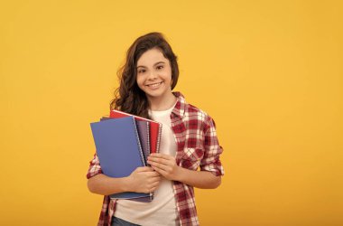 Gülümseyen okul çocuğu, kitaplarla ve bilgiyle çalışmaya hazır.