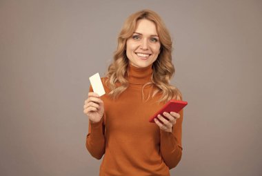 İletişim bilgilerini telefona ekle. Mutlu kızın cep telefonu ve iletişim kartı var. İş iletişimi