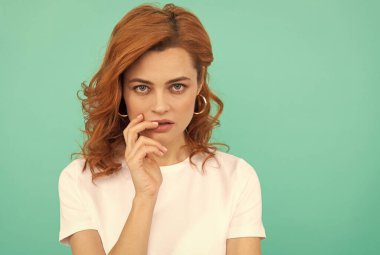 Kıvırcık saçlı seksi kızın mavi arka planda mükemmel bir teni var. Kopya alanı, cilt bakımı.