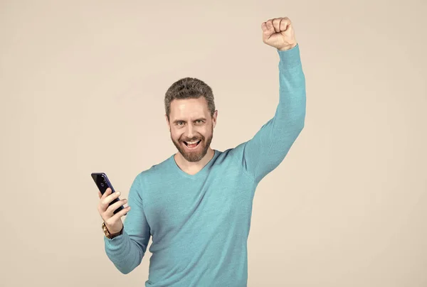 Щасливий успішний чоловік з бородою зі смартфоном, успіх — стокове фото