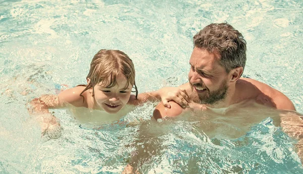 夏のスイミングプールで遊んでいる父と小さな男の子の幸せな家族リゾート — ストック写真