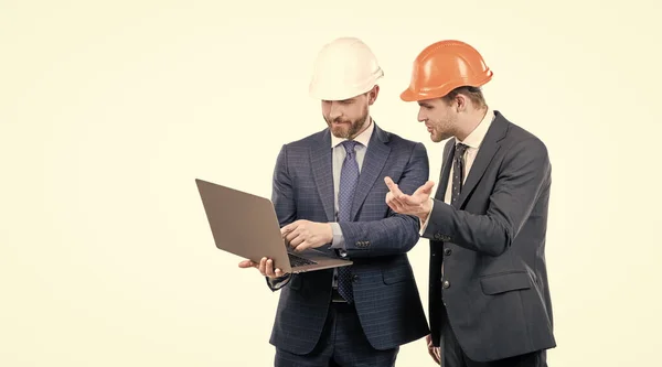 Two businesspeople partners in safety helmet working on laptop online copy space, business partners. — 스톡 사진