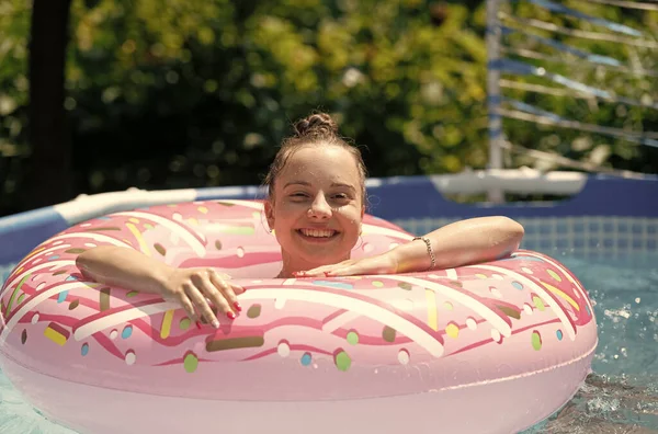 Idealny do pokonania letnich upałów. Szczęśliwa dziewczyna pływa w basenie z pączkami. Dzień zimnego basenu. Wakacje — Zdjęcie stockowe
