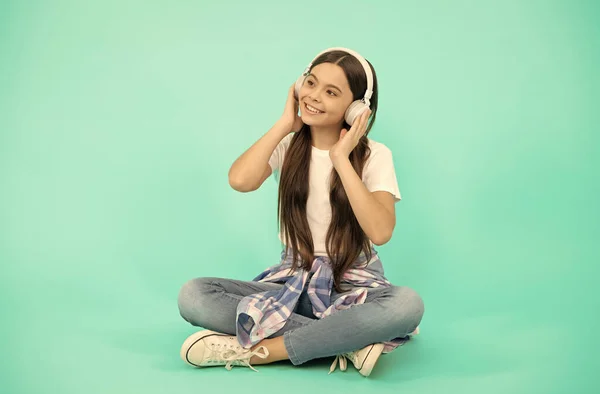 Щаслива дівчина-підліток слухати музику в бездротових навушниках, розвиток дитинства — стокове фото