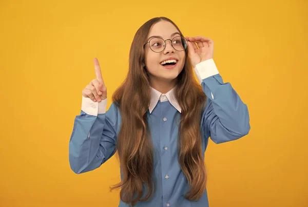 Clever idea. Clever girl in eyeglasses yellow background. School age child with raised finger. Eureka — Fotografia de Stock