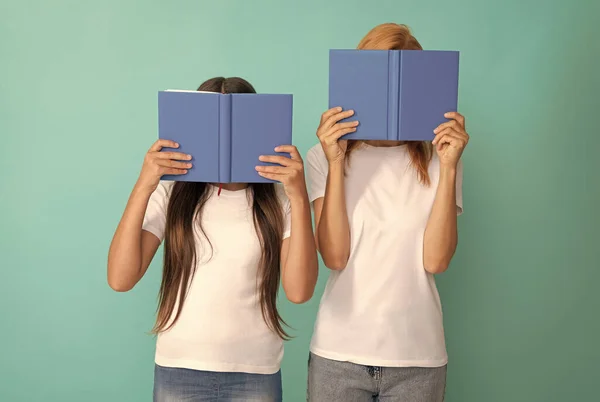 Мати і дочка ховаються за книгами, готовими до навчання, література — стокове фото