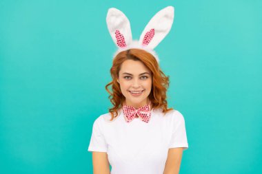 Tavşan kulaklı mutlu Paskalya kadını ve mavi arka planda papyon.