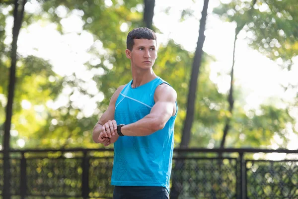 Man sportsman in activewear checking time on smartwatch — 스톡 사진
