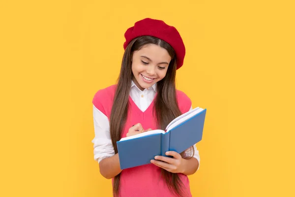 Щаслива дівчина-підліток у французькому береті робить нотатки в блокноті або блокноті, пишучи — стокове фото