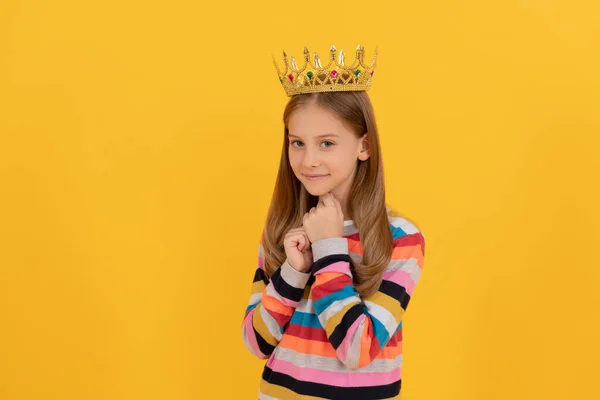 Lächelndes Teenagerkind in Königskrone auf gelbem Hintergrund — Stockfoto